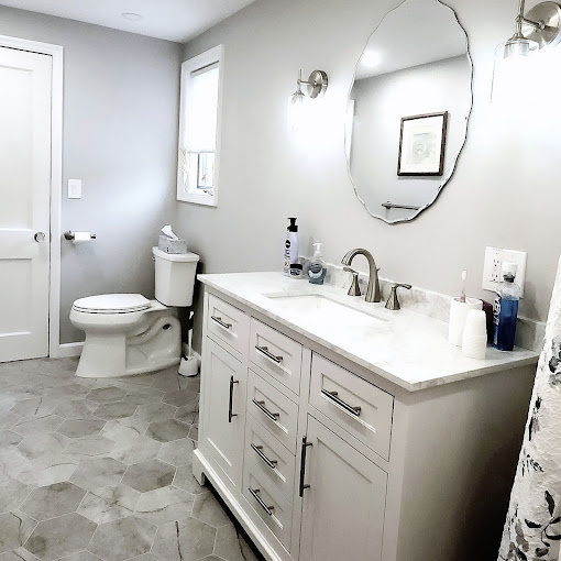 A bathroom with a toilet, sink, and mirror